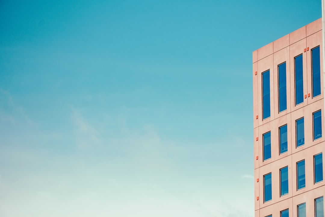 【DeepSeek】V3.1リリース！ハイブリッド推論でAIエージェント強化【2025年最新】 - a tall pink building with blue windows against a blue sky
