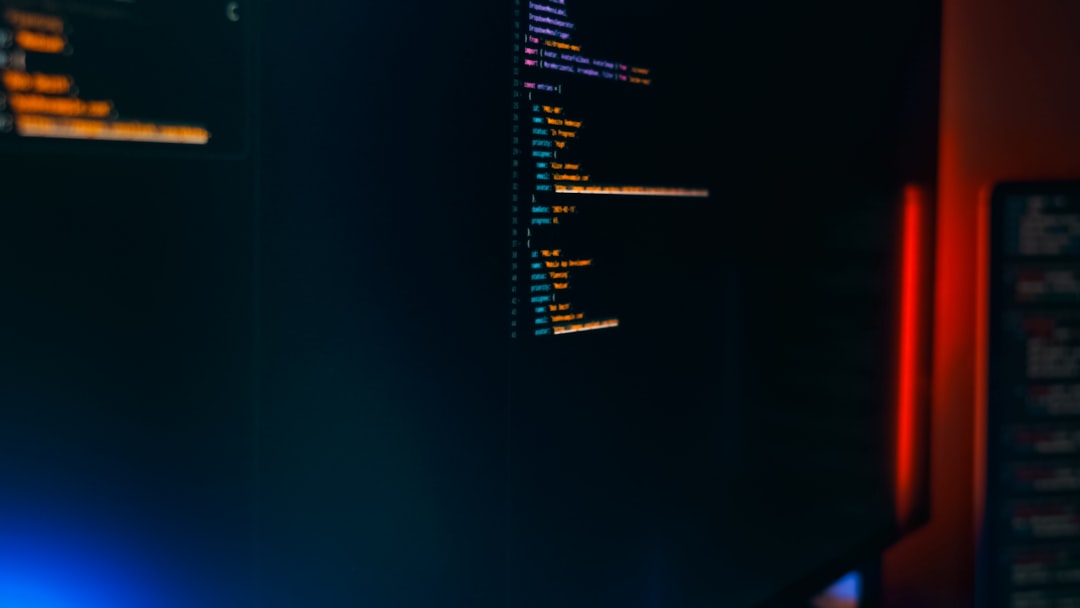 【n8n】バージョン 2024-03-06 リリース！セキュリティ強化の破壊的変更【2024年最新】 - Dark monitor code programming cyber workspace with colorful syntax highlighting and LED lighting.