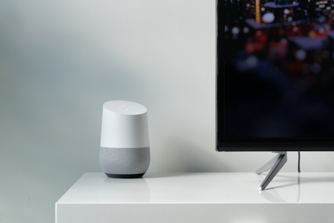 Google HomeとGeminiで進化するスマートライフ：活用術と未来展望 - white and gray Google smart speaker beside black flat screen TV