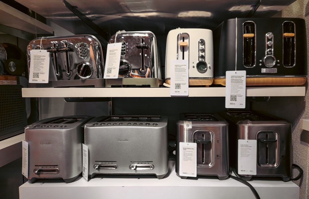 AI搭載スマートキッチンが変える食卓の未来：2026年が転換点か - This image showcases shelves filled with toasters in a retail store, displaying a variety of models, sizes, and designs. Toasters are a staple kitchen appliance, commonly used for making breakfast by quickly browning bre