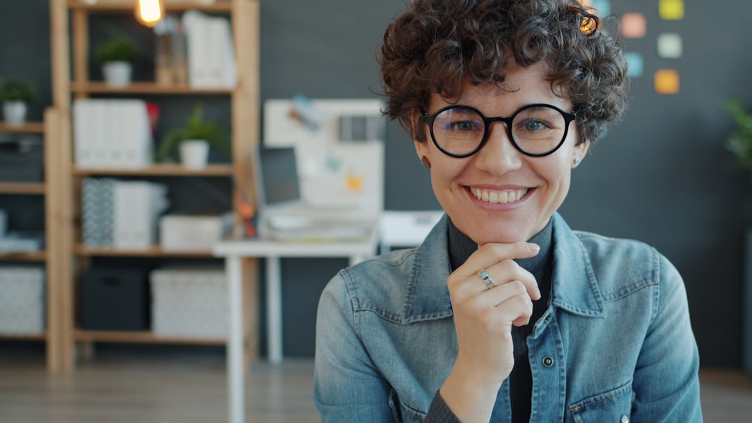 AI時代に忍び寄る「FOBO」とは？職場で感じる無力感と向き合う方法 - portrait of attractive young businesswoman in glasses smiling in creative office looking at camera. Happy people, occupation and business concept.
