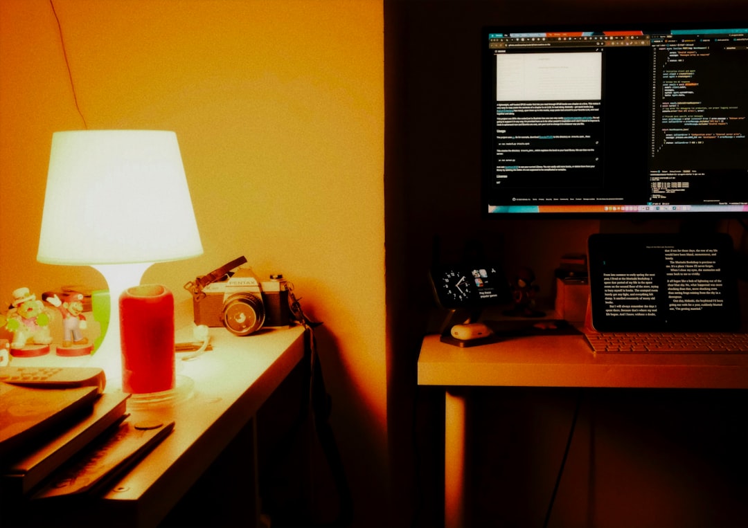 HyperFramesで動画制作をコード化！AIエージェントによる次世代ワークフロー - Desk with computer, lamp, and vintage camera.