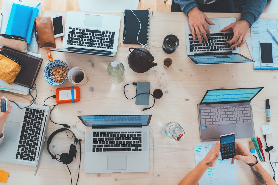 AIコーディングツールのコスト管理術：Uberの事例から学ぶROI最大化 - people sitting down near table with assorted laptop computers